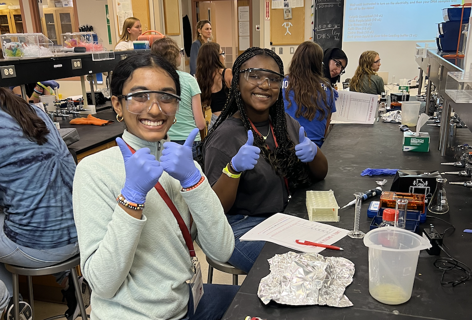 Two students giving a thumbs up during a lab session