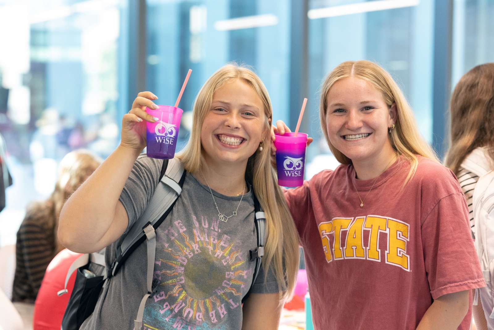 Two students smiling with color changing cups